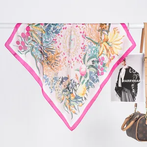 Foulard élégant en satin avec imprimé tropical rose et bordure magenta suspendu sur cintre