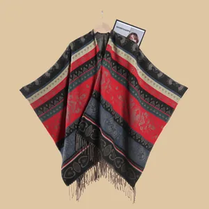 Detail of bohemian jacquard poncho with geometric ethnic patterns and tassel fringe