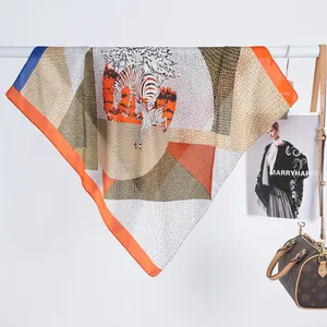 Detailed close-up of 70cm silk-like scarf with zebra print and orange geometric patterns