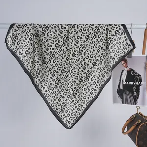 Close-up showing the leopard print pattern and satin texture of a draped scarf