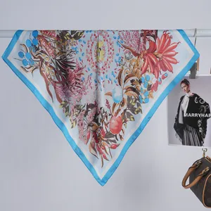 Détail d'un carré de soie avec bordure bleu ciel et motifs floraux élégants et colorés