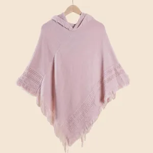Détail du poncho en tricot rose pâle à capuche avec ourlet à franges et texture tissée
