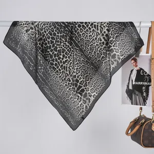 Detail of leopard print satin scarf showing elegant drape and monochromatic pattern