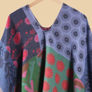 Detail of colorful floral patchwork knitted shawl with ethnic patterns and soft texture