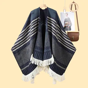 Détail d'un châle en tricot à motifs ethniques avec des franges blanches et une texture douce