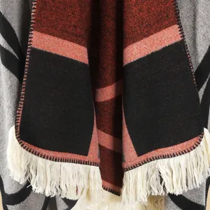 Détail de châle en maille géométrique montrant le tissu et les franges blanc cassé