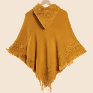 Détail du motif tricoté d'un poncho jaune gingembre à capuche et ourlet à franges