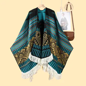 Poncho ethnique en maille jacquard bohème avec franges blanches sur fond beige clair