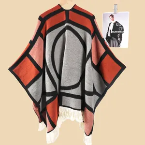 Détail du poncho en tricot géométrique avec de longues franges et un motif ethnique épais