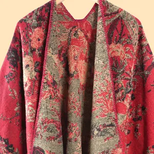 Detailed close-up of floral jacquard pattern and knitted texture on a red retro shawl