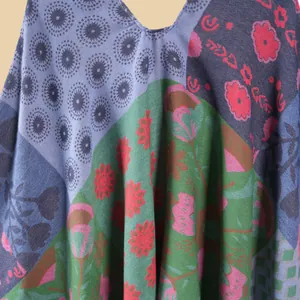 Detailed view of bohemian floral patchwork knit poncho with V-neckline and textured fabric