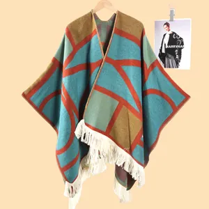 Détail du châle en tricot bohème avec motifs géométriques et franges blanches épaisses