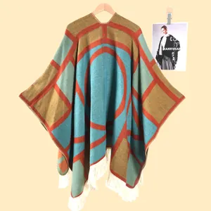 Détail du motif géométrique coloré et des longues franges blanches sur un châle bohème