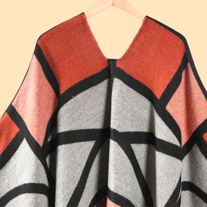 Détail d'un poncho en maille géométrique avec franges et col en V de style ethnique