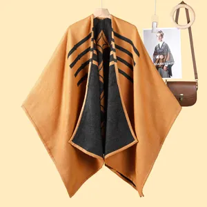 Poncho da donna in maglia giallo senape e nero con motivi geometrici e strisce moderne