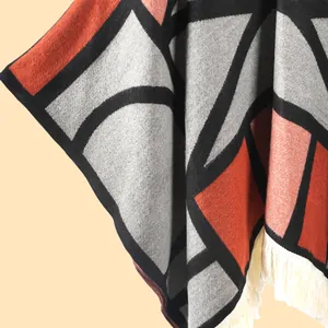 Gros plan du châle en tricot géométrique avec motif ethnique et détails de franges blanches