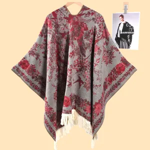 Detail of vintage floral knit poncho with red roses, grey base, and long fringe tassels