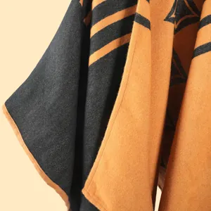 Dettaglio macro dello scialle in maglia double-face con bordi rifiniti in arancione
