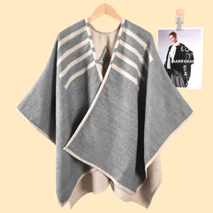 Macro di scialle in maglia grigio scuro con bordo bianco crema e dettagli a righe