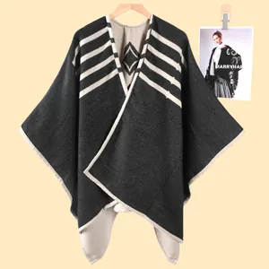 Dettaglio ravvicinato della mantella in maglia con trama a righe e motivi geometrici