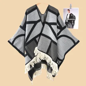 Detailansicht des geometrischen Strickmusters und der cremeweißen Fransen am Poncho