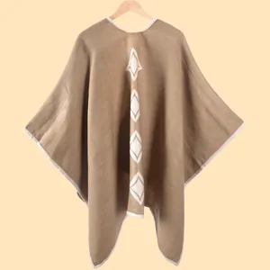 Dettaglio di uno scialle in maglia con motivi geometrici a rombi e bordo rifinito
