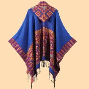 Detail of bohemian knit shawl with floral patterns and long black tassels at the hem
