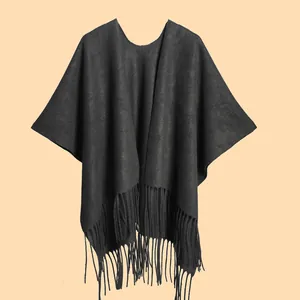 Close-up of black cashmere-like shawl featuring long tassels and high-end knit texture
