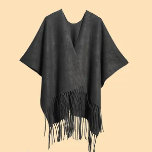 Detail of classic black thick knit shawl with elegant V-neck and decorative fringe hem