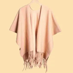 Detailed view of beige tassel shawl with soft thick fabric texture and elegant fringe