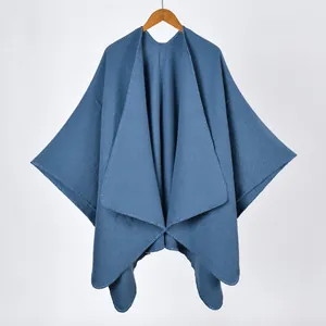 Solid blue knit poncho shawl with side slits and draped open front design