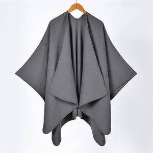 Close-up of deep grey knit poncho featuring split hem and premium seam stitching details