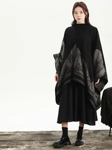 Detail of elegant black and grey knitted poncho with traditional landscape jacquard pattern
