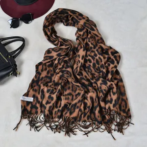 Close-up of leopard print cashmere scarf with fringe edges and 100% cashmere label