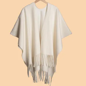 Detailed view of cream white fringed shawl featuring soft knit texture and long tassels