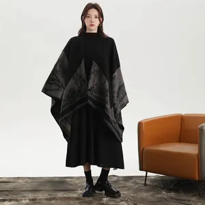 Detail of knit poncho with elegant mountain landscape print and black-grey color block