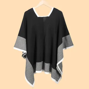 Detail of color-block knit shawl featuring soft grey texture and elegant white border