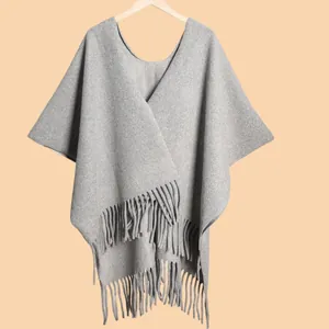 Close-up of thick dark grey knitted shawl featuring soft texture and long fringe details