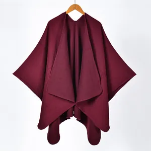 Detailed texture of burgundy cashmere-like knit shawl with irregular draped hemline