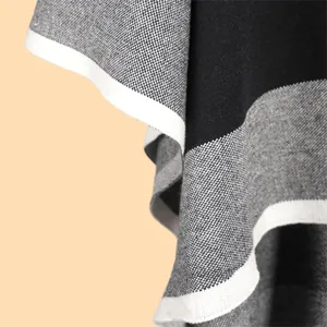 Macro detail of high-quality knitted shawl showing grey color-block texture and white edges