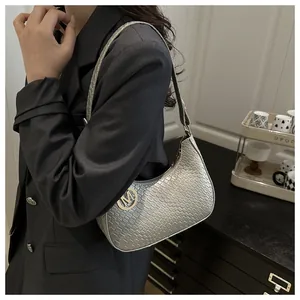 Detail of silver crocodile pattern shoulder bag with a metallic finish and gold M logo