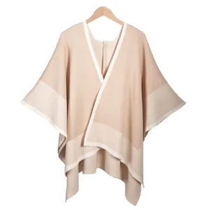 Elegant beige knitted cape shawl for women with cream contrast trim and V-neckline