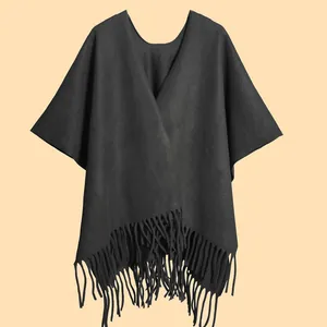 Detailed view of black thick shawl wrap with elegant long tassels and warm fabric texture