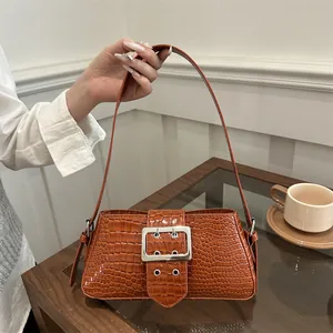 Brown crocodile embossed leather shoulder bag with oversized silver buckle and top handle