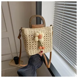 Detailed texture of beige woven straw bag with wooden handles and plush flower charm