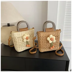 Detailed view of handmade woven straw bags with wooden handles and floral charm