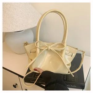 Detailed view of beige bow bucket bag with supple PU leather and smooth metal zipper