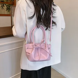 Pink glossy bow bucket bag for women with top handles and adjustable crossbody strap