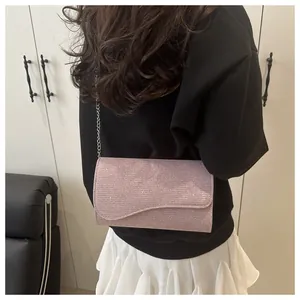 Detail of pink rhinestone envelope clutch with curved flap and silver chain strap