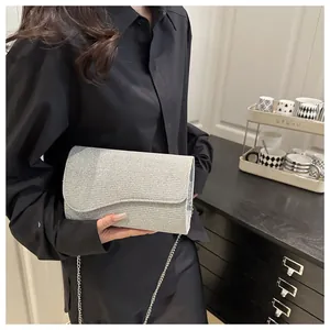 Detail of silver sequin evening bag with wavy edge flap and metallic chain strap